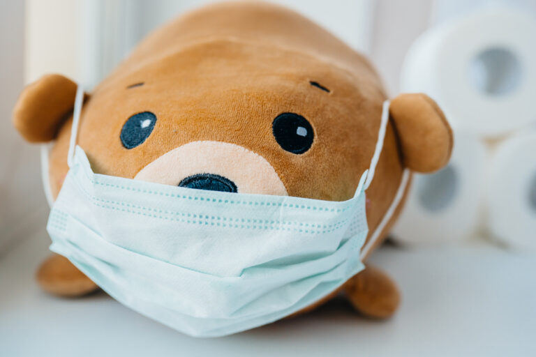 Disposable medical protective face mask on brown teddy bear